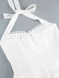 Dettaglio ravvicinato di un abito bianco a lupetto con bordo in pizzo e pieghe eleganti