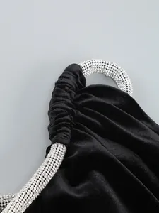 Primer plano de vestido de terciopelo negro con detalle de tirante de strass