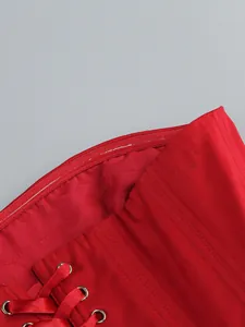 Dettaglio della striscia antiscivolo in silicone e lacci in raso rosso su un abito da sera