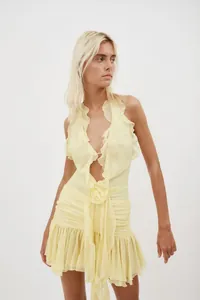 Detailed close-up of a sexy yellow halter dress with elegant ruffles and 3D floral accents