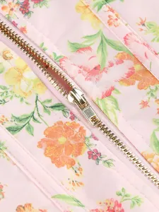 Dettaglio della cerniera in metallo argentato su tessuto a stampa floreale rosa con fiori