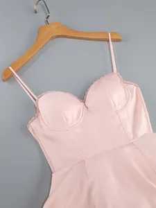 Detail of a pink satin strappy bustier dress with delicate lace trim and cups.