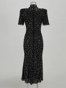 Back view of a black fishtail evening dress featuring intricate sparkling rhinestone patterns.