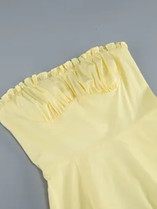 Vista dettagliata dell'abito a fascia giallo con scollatura a balze e busto a pieghe