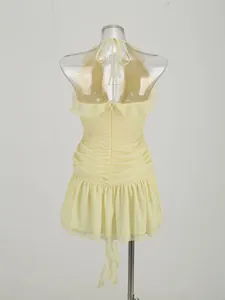 Detailed back view of a yellow halter dress featuring ruffled edges and shirred textures