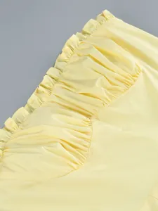 Dettaglio che mostra il bordo delicato con volant e l'arricciatura di un vestito bustier