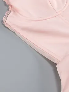 Detailed view of a pink cocktail dress showing exquisite lace trim and soft mesh lining