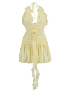 Close-up detail of a yellow halter neck dress featuring ruffles and a 3D rose decoration