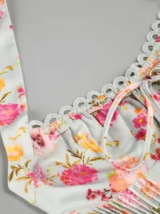 Dettaglio ravvicinato di un abito floreale con scollo all'americana e bordo in pizzo