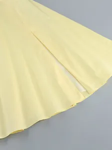 Primo piano dell'orlo dell'abito giallo svasato che mostra trama e cuciture sottili