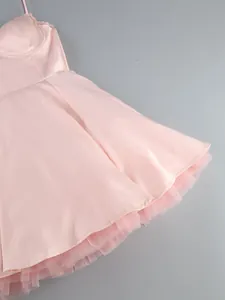 Detail showing the tulle lining and flared hem of the pink camisole bustier mini dress.