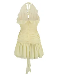 Detailed back view of a light yellow halter neck mini dress with ruffles and ruched fabric