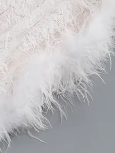Close-up detail of exquisite white floral lace and soft feather trim on a luxury dress