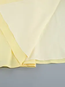 Primo piano degli strati di tessuto giallo che mostrano la fodera e i dettagli dell'orlo.