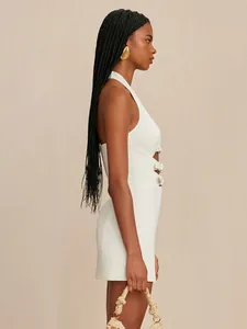 Side profile of an elegant white halter mini dress with side cutouts and gold buckles