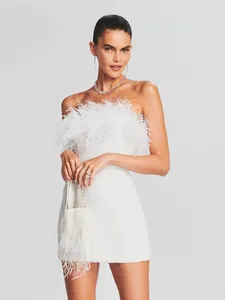Detalle del vestido blanco de lentejuelas con elegante adorno de plumas de avestruz.