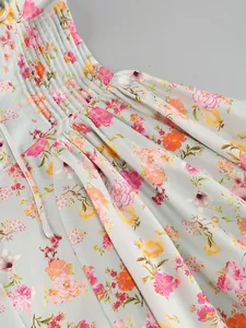 Dettaglio di abito floreale con scollo all'americana e vita plissettata elegante