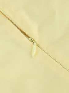 Dettaglio ravvicinato della cerniera nascosta e del tessuto twill in giallo chiaro