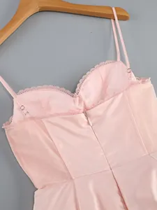 Close-up of pink satin dress with mesh panels, lace trim, and hidden back zipper detail