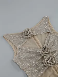 Detail von funkelnden Strasssteinen und 3D-Blumenapplikationen auf Mesh-Kleid