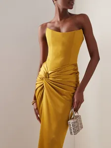 Elegant mustard yellow strapless corset maxi dress featuring a chic draped knot waist detail