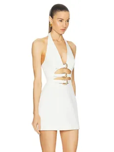 Detail of decorative metal buckles and cut-out design on a white halter mini dress.