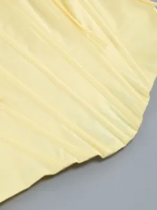 Primo piano della delicata struttura a stecche e delle cuciture sul corpetto giallo.