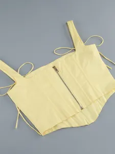 Vista dettagliata di un crop top a corsetto giallo con zip anteriore e lacci laterali regolabili