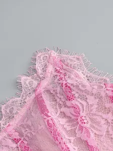 Detailed view of pink floral lace fabric and delicate eyelash trim on a corset dress