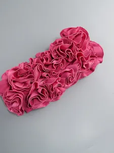 Dettaglio della trama a balze floreali 3D rosa su un abito da sera a fascia aderente.