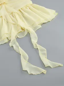 Detail of ruffled edges and light yellow chiffon fabric on an elegant evening dress.