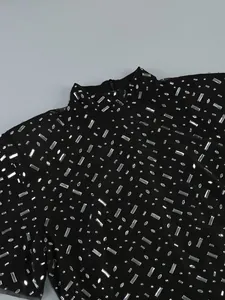 Detail of high neck black evening dress with shimmering rhinestone embellishments