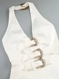Detailed view of a white halter neck dress with three rhinestone-encrusted buckles