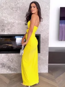 Elegant yellow ruched off-shoulder formal gown with twist detail in a modern room.