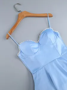 Detail view of light blue satin dress with corset bodice and white lace trim.