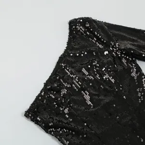 Dettaglio di paillettes nere scintillanti su un elegante abito da sera monospalla