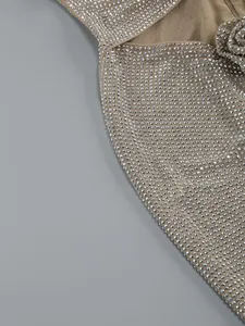 Detailaufnahme von silbernen Strasssteinen und Blumendekor auf einem nudefarbenen Abendkleid