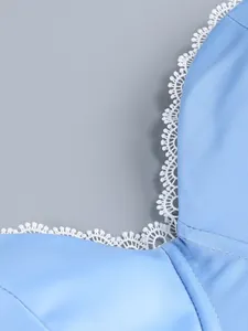 Detail showing the delicate white lace trim on the neckline of a light blue summer dress.