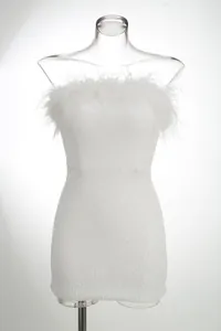 Detalle de vestido palabra de honor con lentejuelas blancas y elegantes plumas de avestruz.