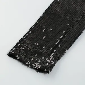 Vista dettagliata delle paillettes nere scintillanti sulla manica di un abito di lusso
