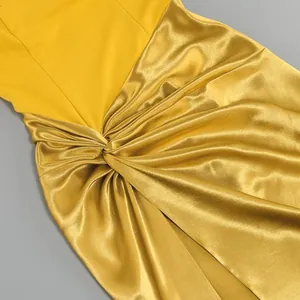 Detail of yellow satin evening dress showing waist twist and elegant fabric drapes