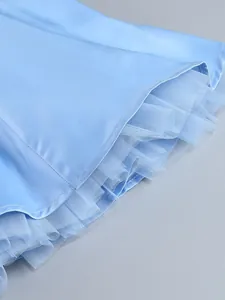 Detailed view of light blue satin dress hemline featuring puffy mesh tulle lining