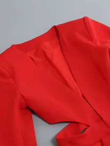 Close-up detail of vibrant red V-neck blazer featuring sexy waist cut-out design and long sleeves.