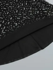 Macro detail view of shimmering rhinestones on black mesh fabric for evening gown
