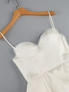 Close-up of white corset dress featuring delicate lace trim and satin fabric texture