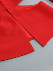 Close-up of the elegant red blazer waist cut-out detail from a two-piece fashion suit set