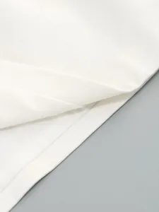 Macro view of high-quality white twill fabric texture and clean hemline of this chic dress