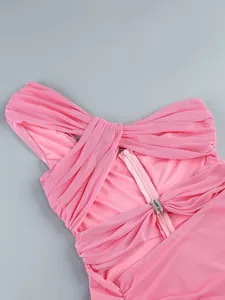 Detailed view of the pink off-the-shoulder knotted dress with a rhinestone buckle