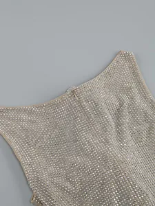 Nahaufnahme glitzernder silberner Strasssteine und Reißverschluss an beige Partykleid