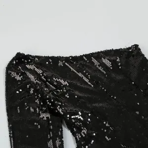 Primo piano di paillettes nere su un abito da sera sexy monospalla a maniche lunghe